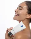 Cream Cleanser de la marca Is Clinical: Mujer sonriendo mostrando el producto