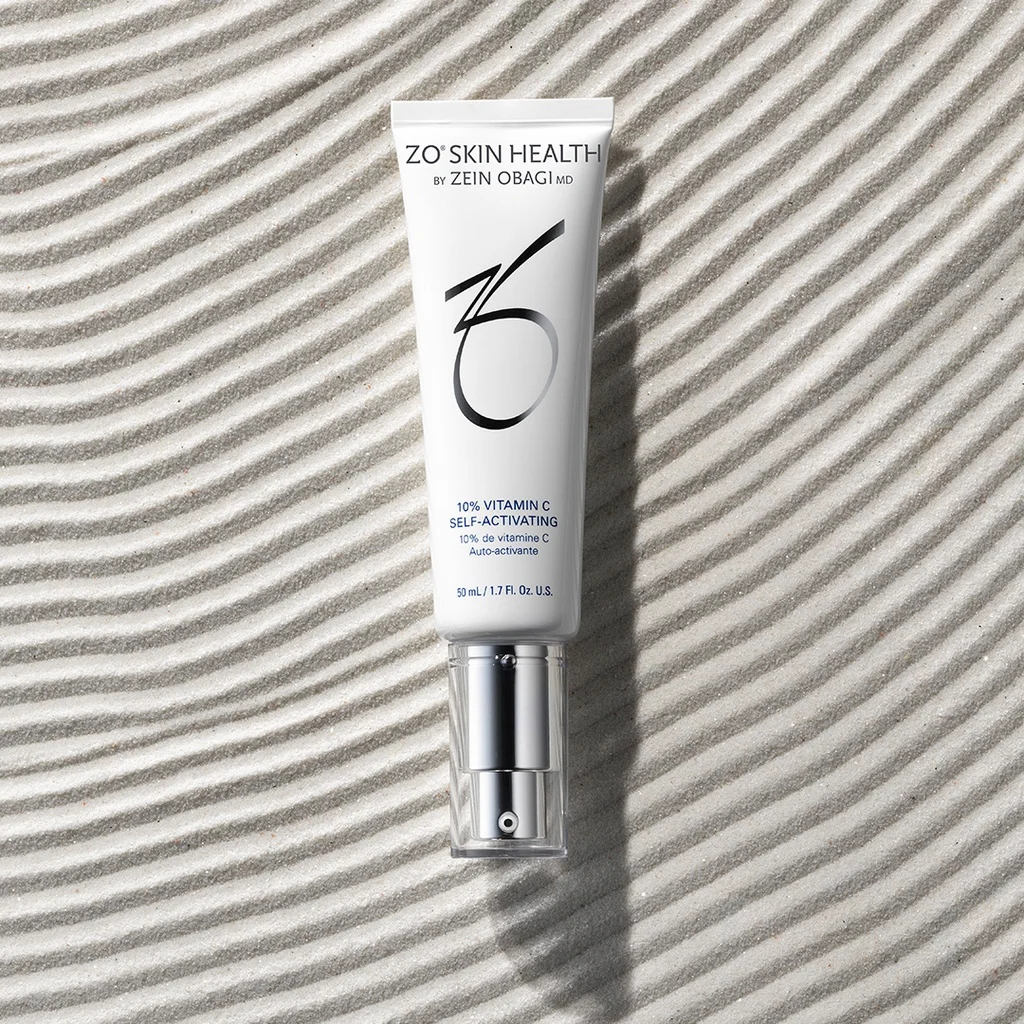 10% Vitamin C de la marca ZO SKIN HEALTH: Producto vista superior en suelo textura arenosa