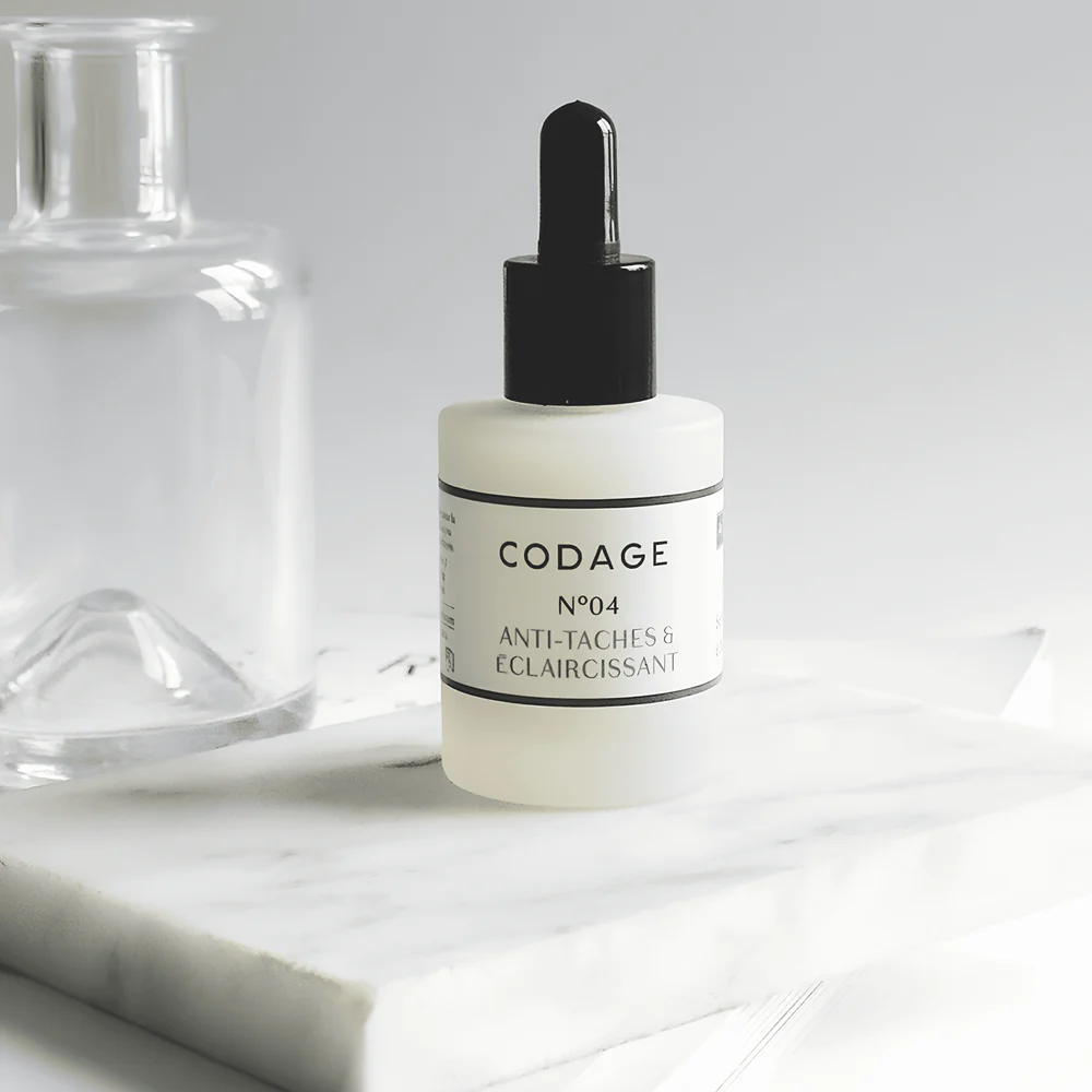 SERUM N°4 - Anti-spots & Lightener de la marca Codage: Producto sombre fondo con materiales acabados en cuarzo